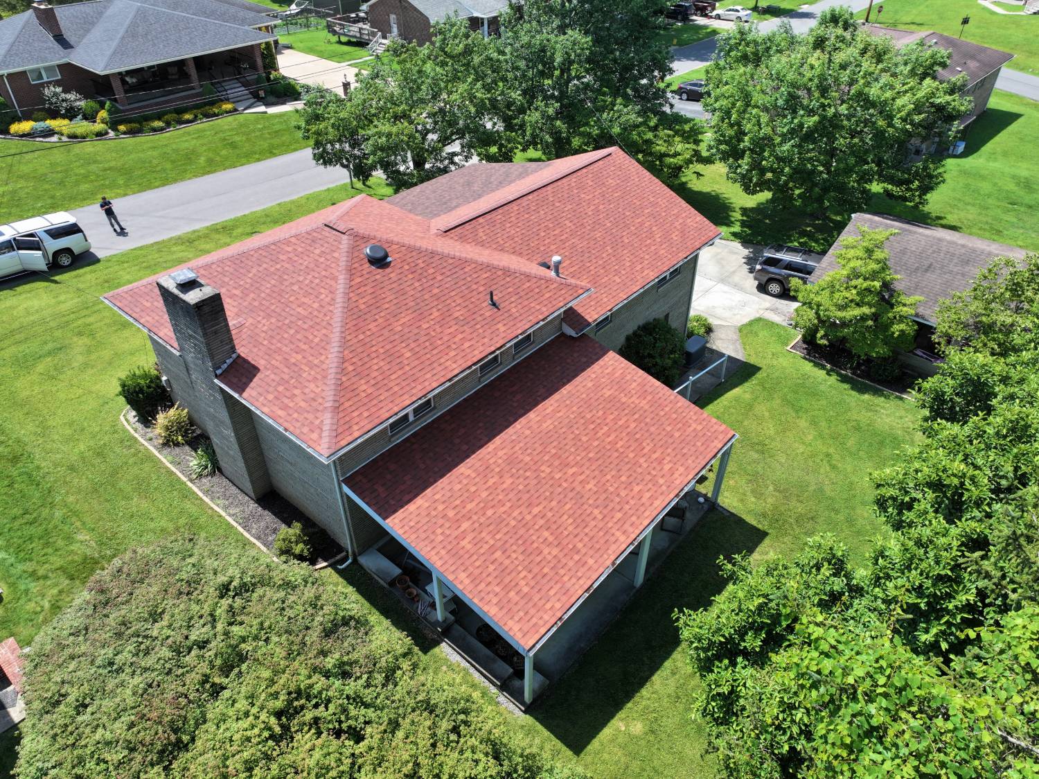 Morgantown WV brick home after roof replacement by Eclipse Construction, with new red architectural shingles